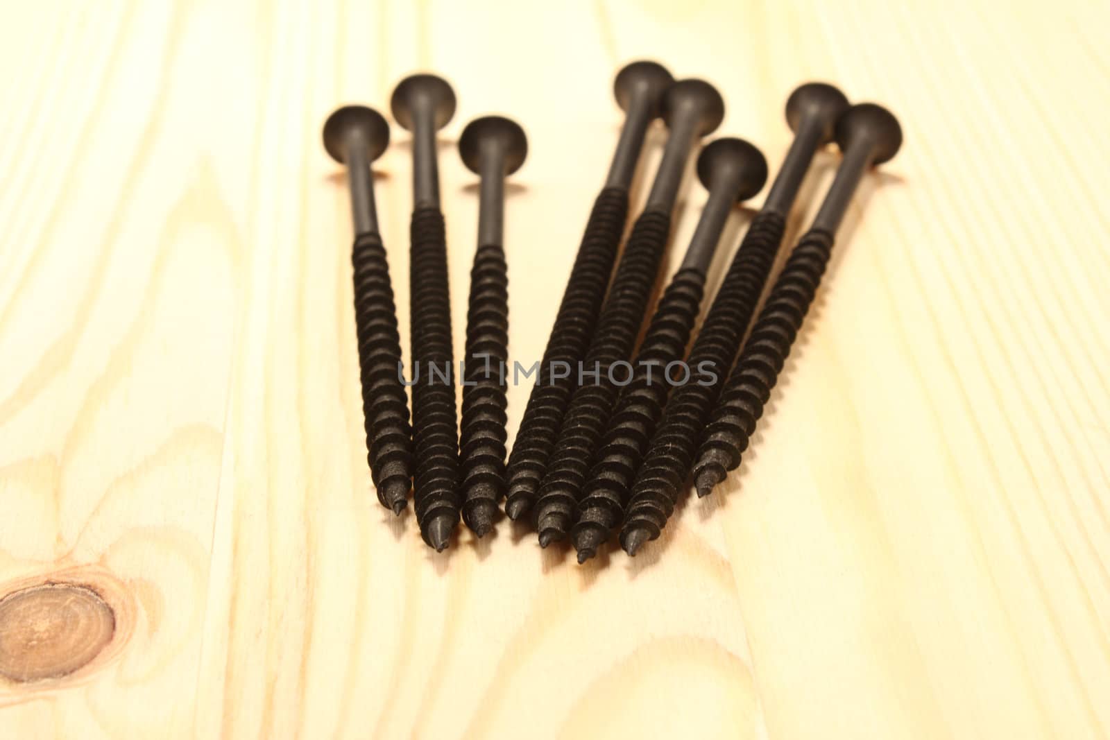 Long black screws on wood table