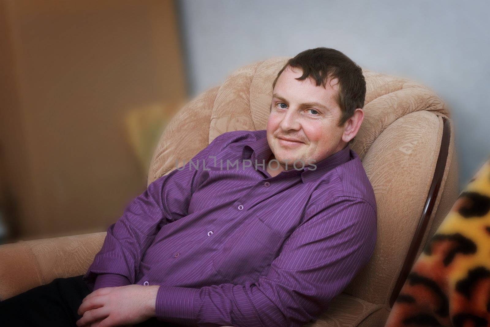 Portrait of a smiling young man in a chair