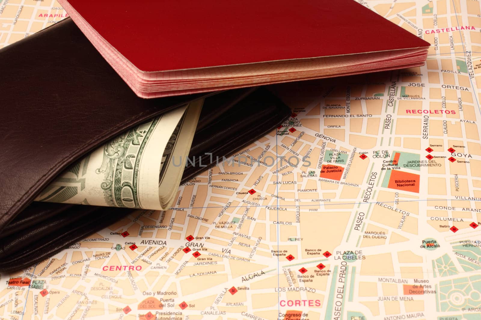 Wallet with dollar bills and passport on city map background.