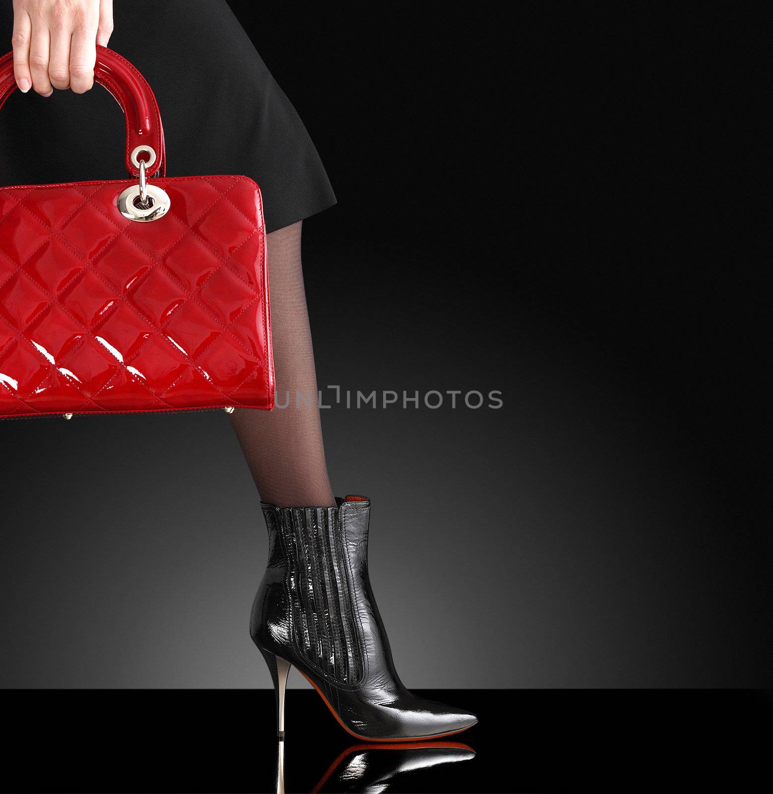 fashionable woman with a red handbag, only legs