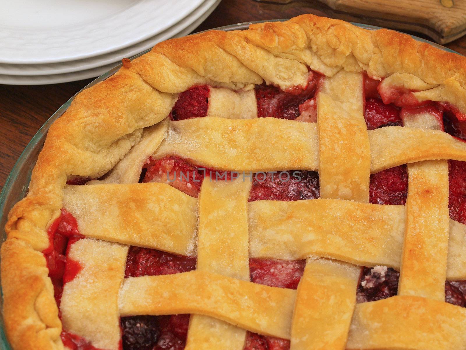 Fresh Baked Three-Berry Pie with Lattice Crust with Plates and Knife