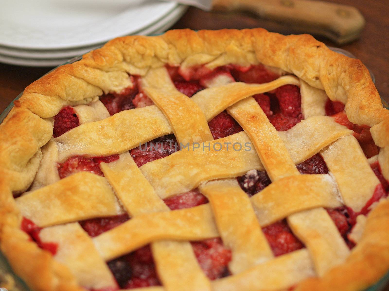 Fresh Baked Three-Berry Pie with Lattice Crust with Plates and Knife
