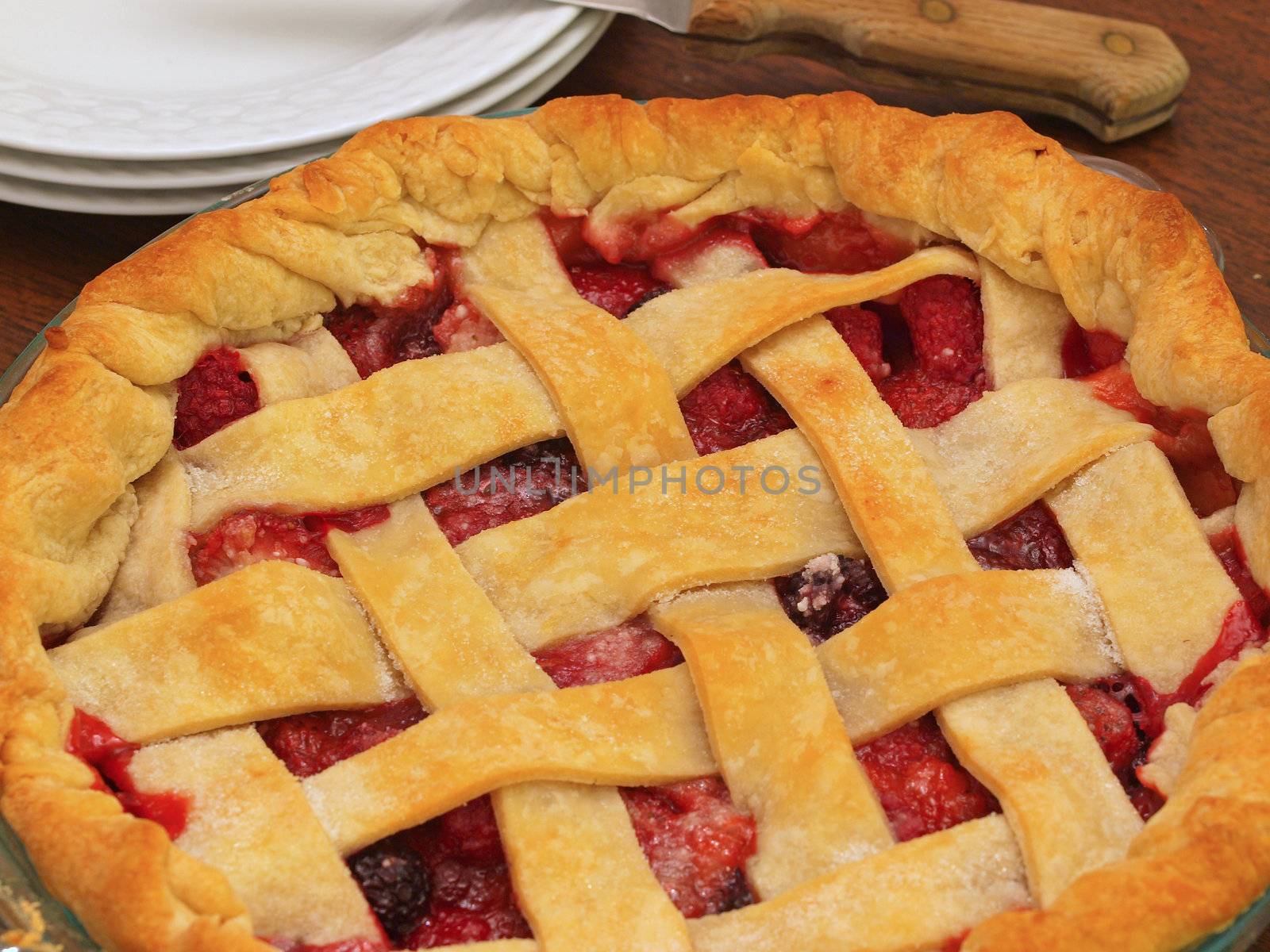 Fresh Baked Three-Berry Pie with Lattice Crust with Plates and Knife