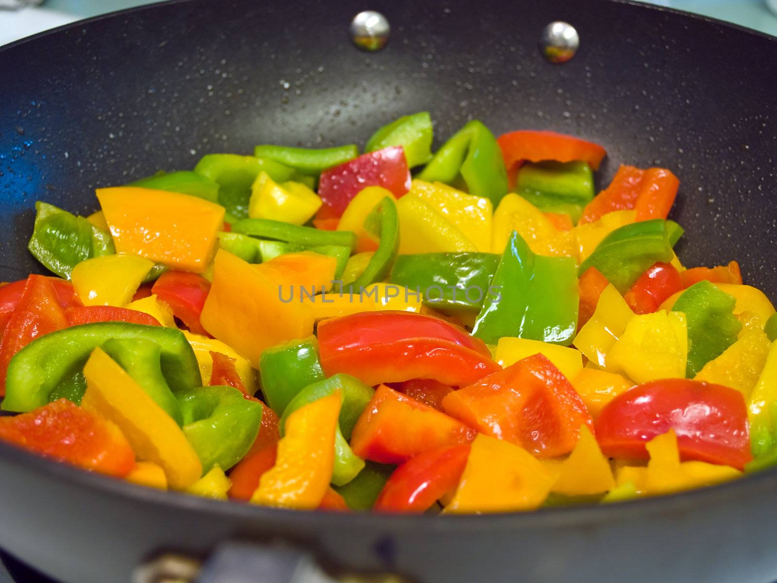 Frying red, green and yellow bell peppers