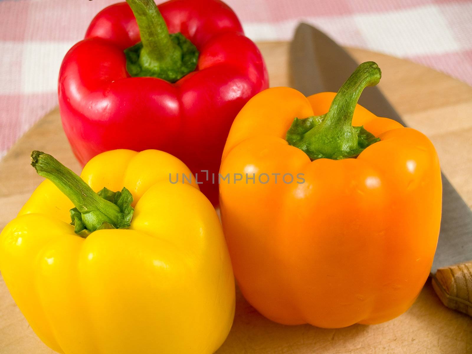 Bell Peppers on a Wooden Cutting Board with Knife