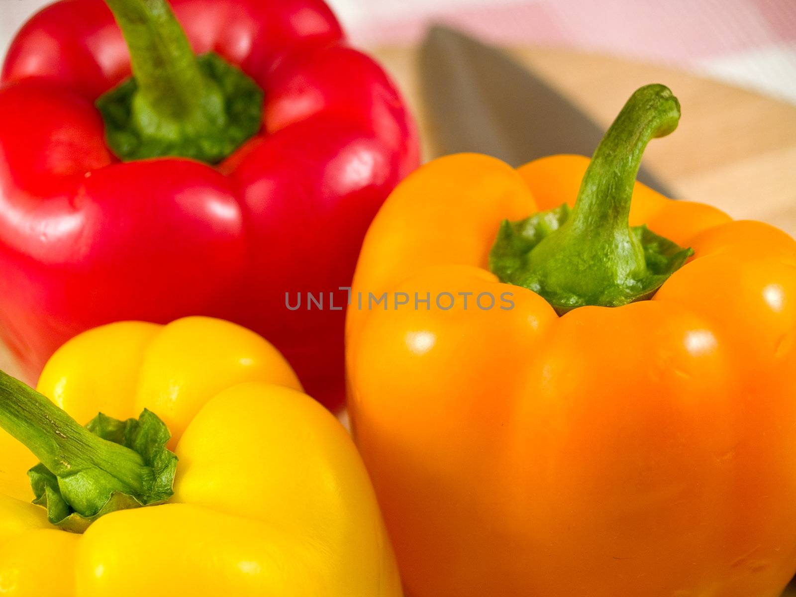 Bell Peppers on a Wooden Cutting Board with Knife