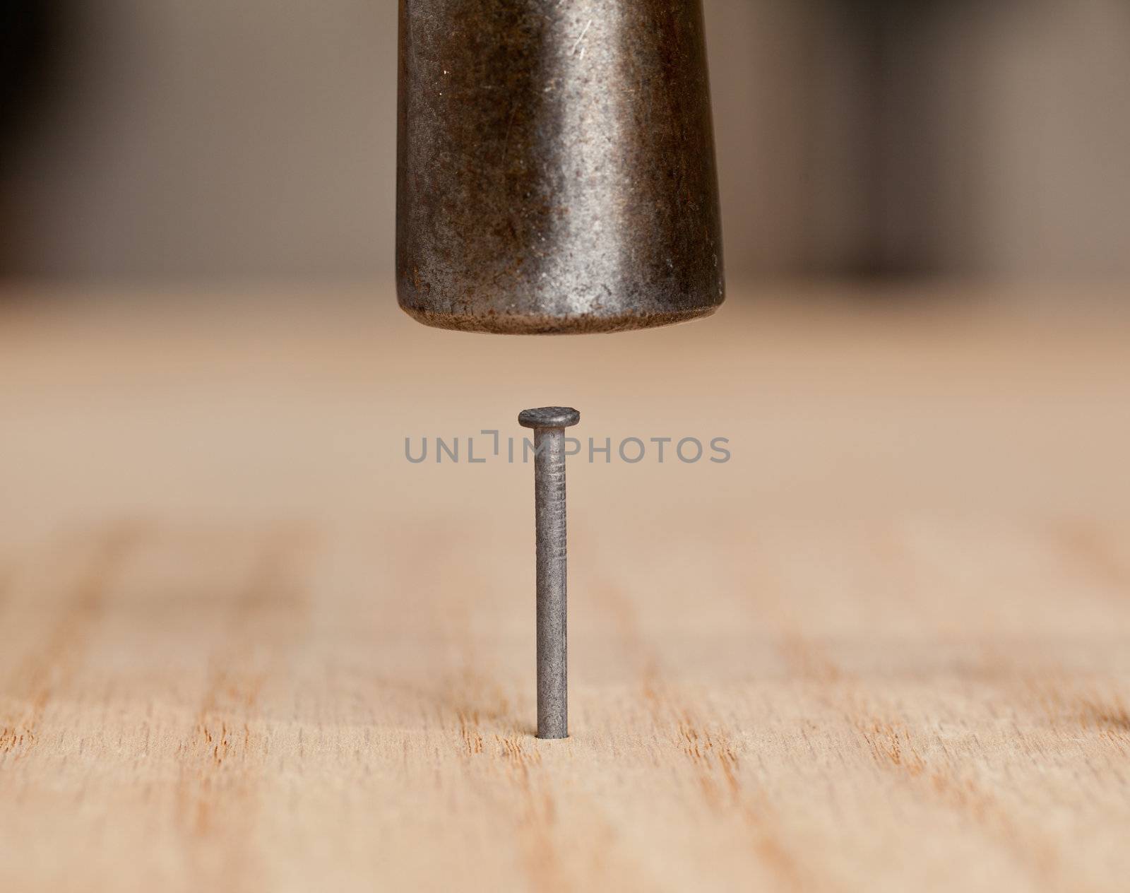 Nail being driven into wood by hammer head