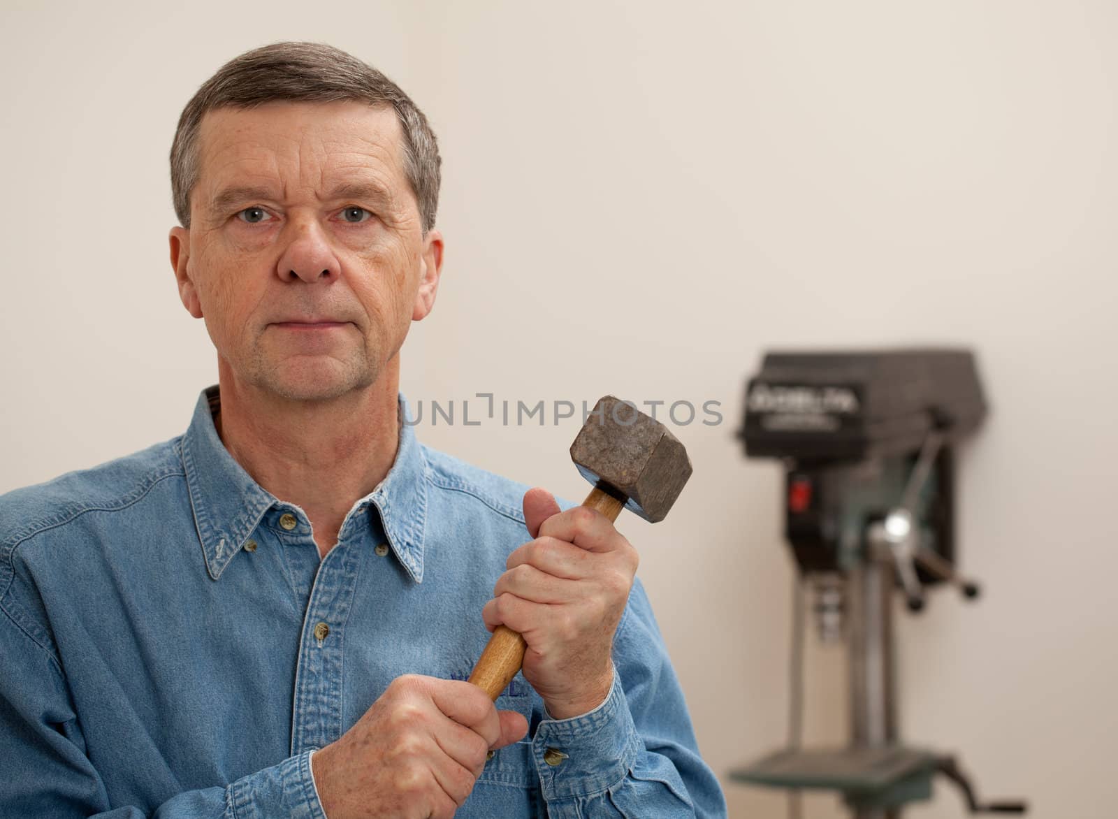 Senior man holding a large hammer by steheap