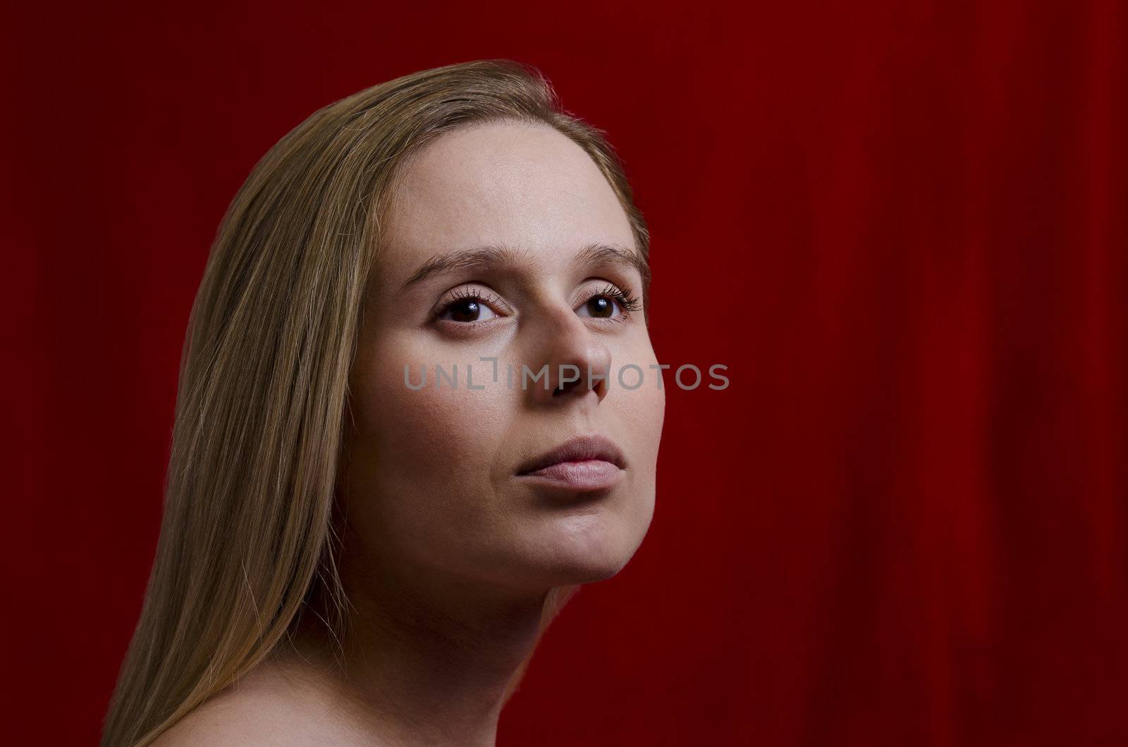 portrait of a young blonde woman on red background