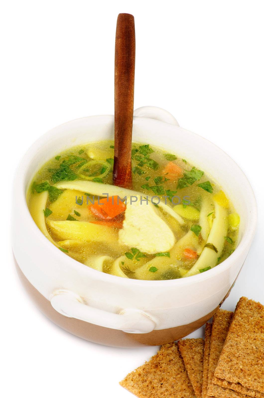Chicken Noodle Soup with Parsley and Carrot in White Bowl with Wooden Spoon and Crispy Bread closeup on white background