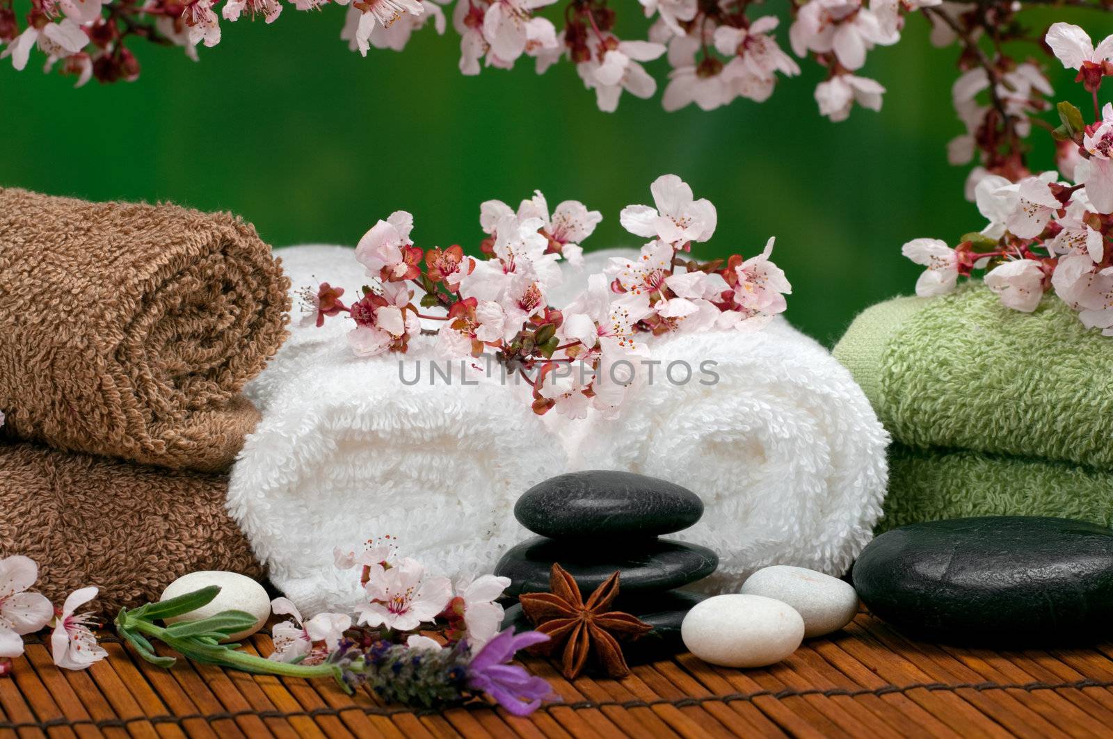 Spa scene with pebbles, lavender, towels and cherry blossoms