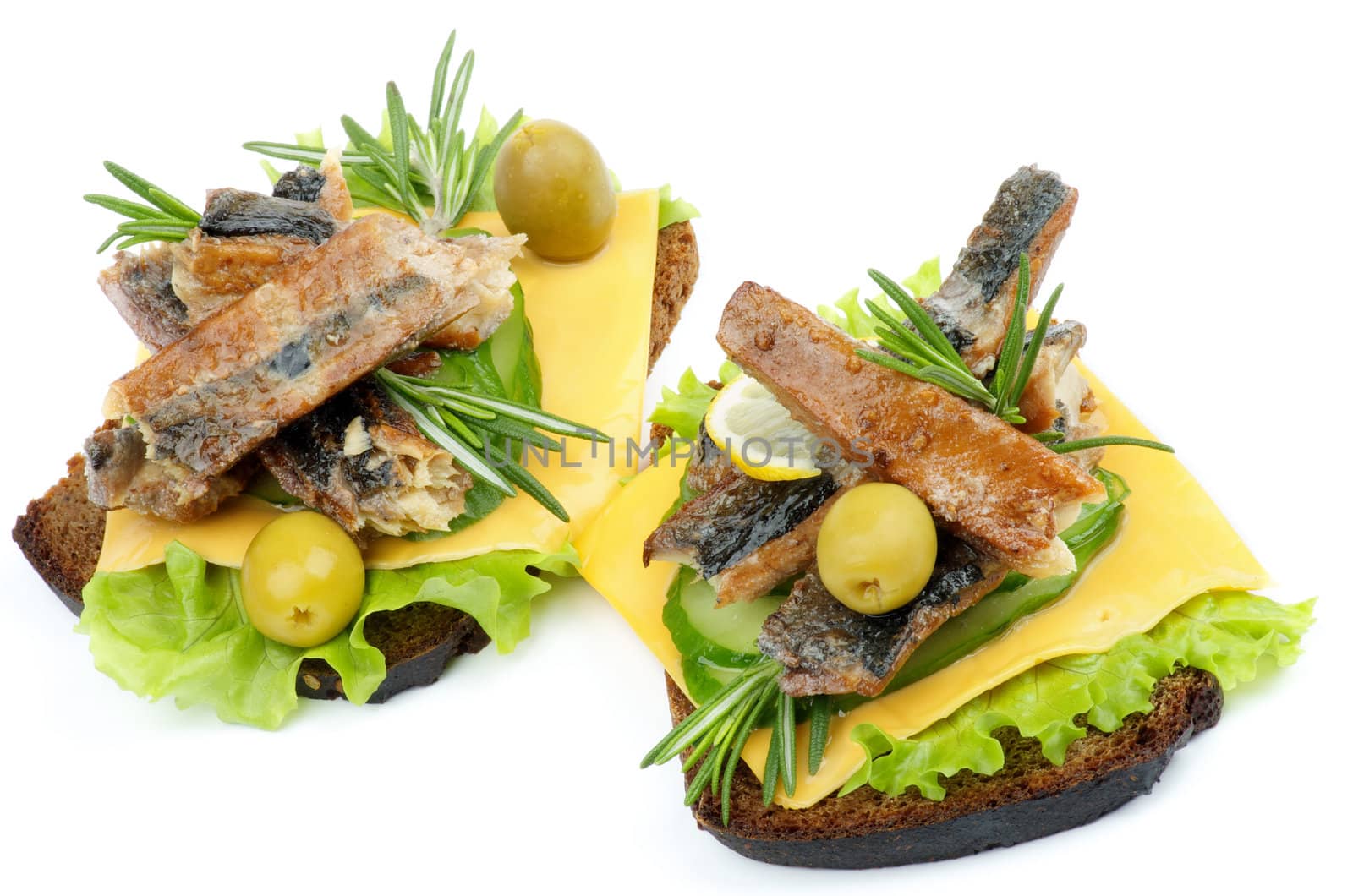 Two Sandwiches with Smoked Sardines, Cucumber, Cheese, Green Olive, Lettuce and Whole Wheat Bread closeup on white background