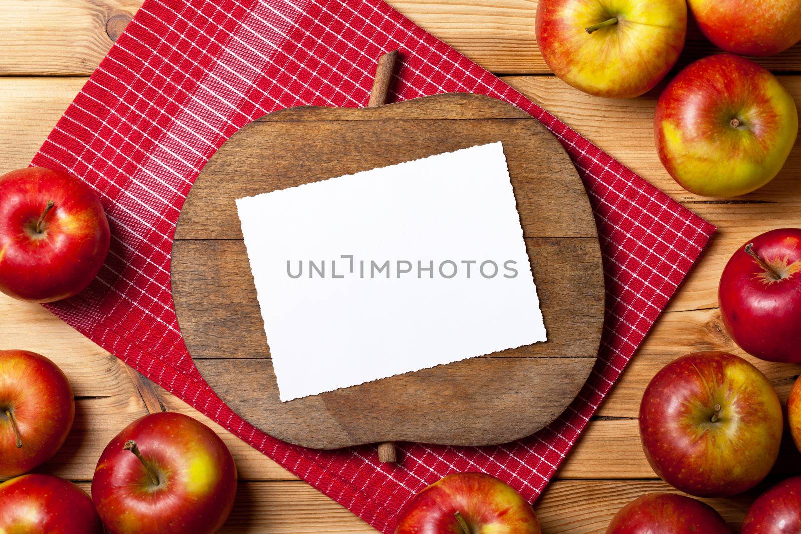 Apples on wooden table. Composition with fresh fruits and cutting board with apple shape. Empty room for text