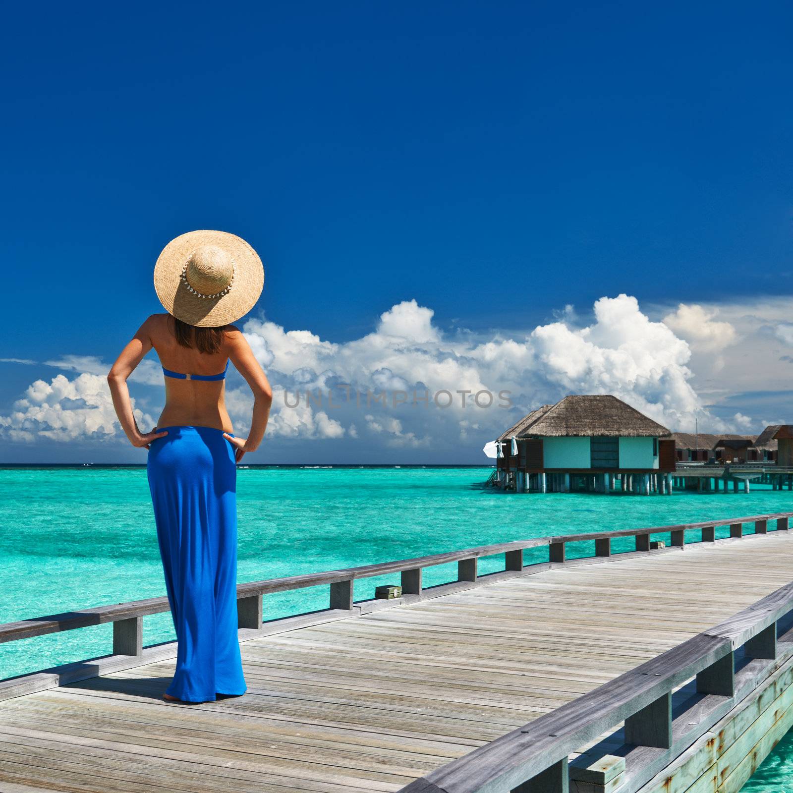 Woman on a tropical beach jetty at Maldives