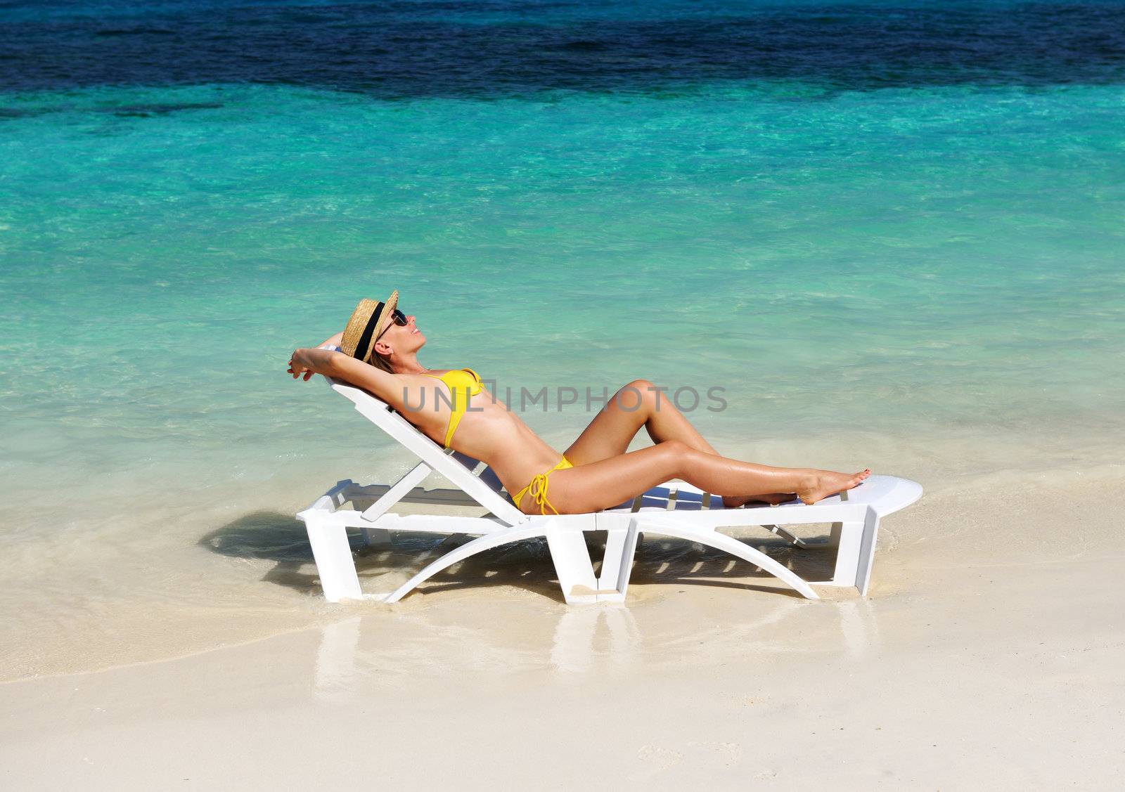 Girl on a tropical beach with hat