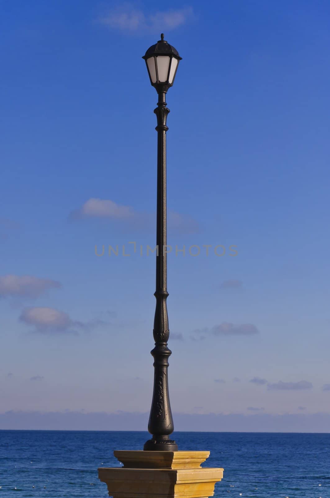 the street lamp against the background of sea and blue sky