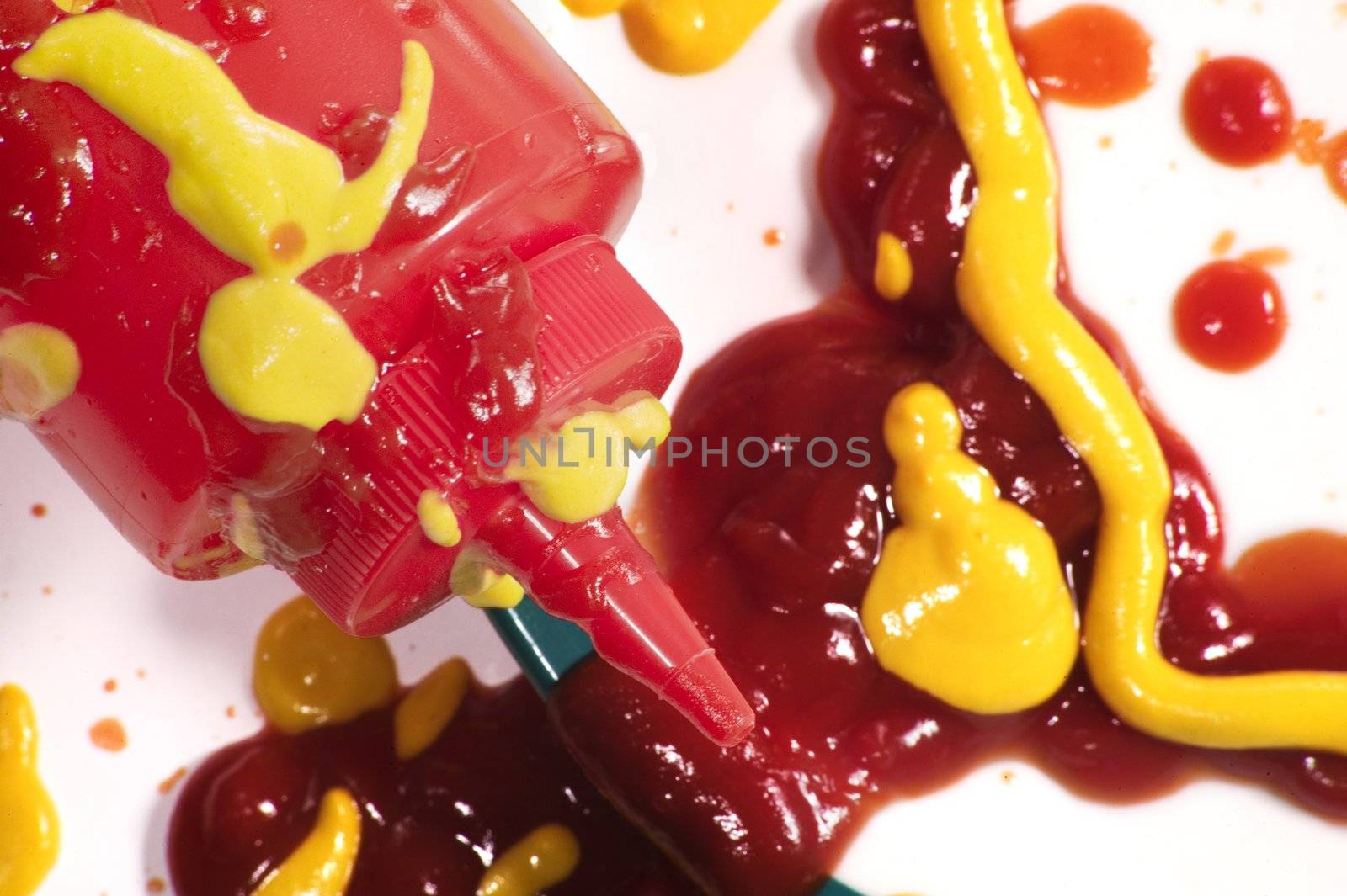 Ketchup squeeze bottle and messy condiments on a plate.