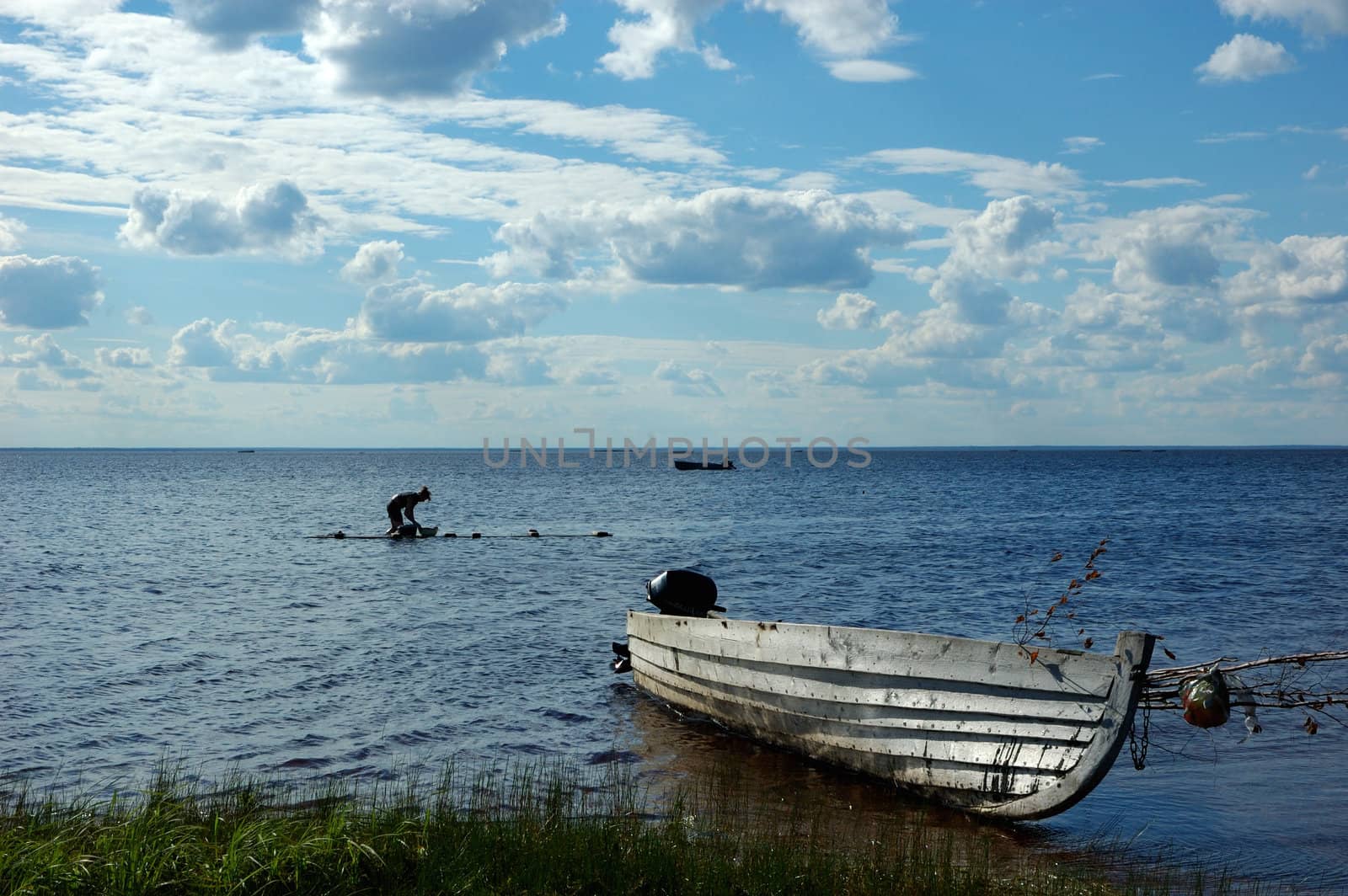 Lake view with old fishing boat and washing woman by wander