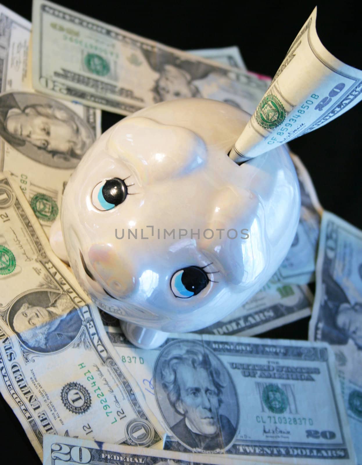 Ceramic piggy bank stuffed with twenty dollar bills.; by jarenwicklund