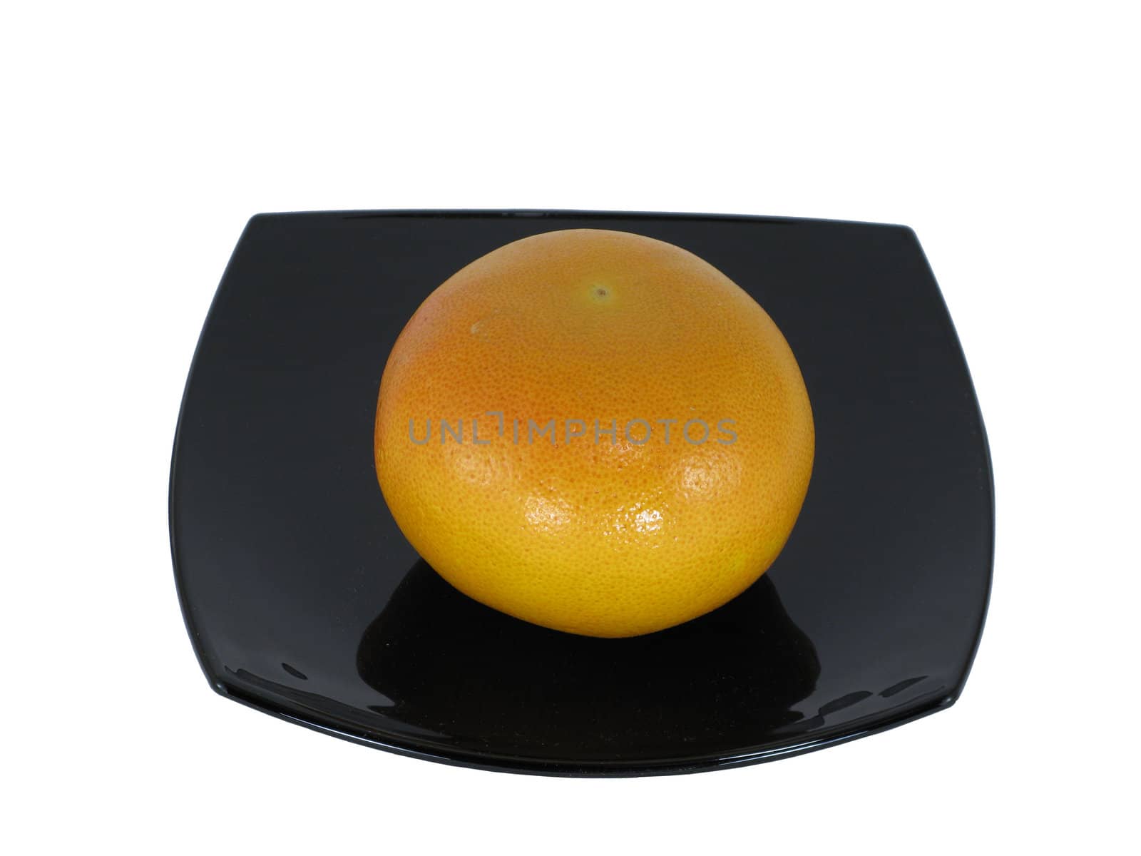 Grapefruit on black dish isolated on white