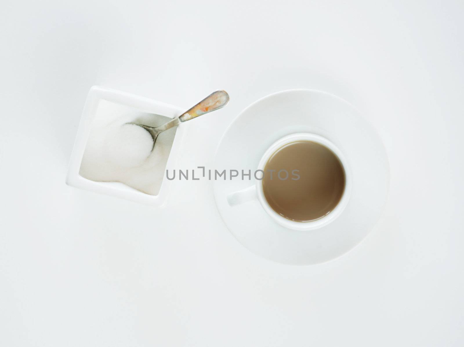 Coffe in espresso cup and sugar container on a white background.
