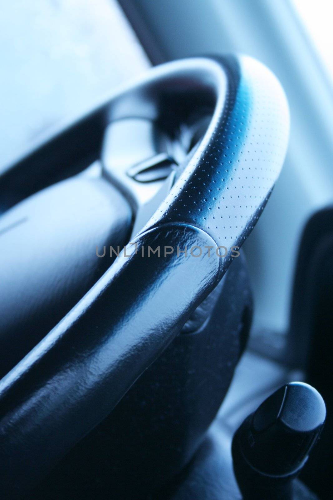 Black leather steering wheel of a SUV; by jarenwicklund