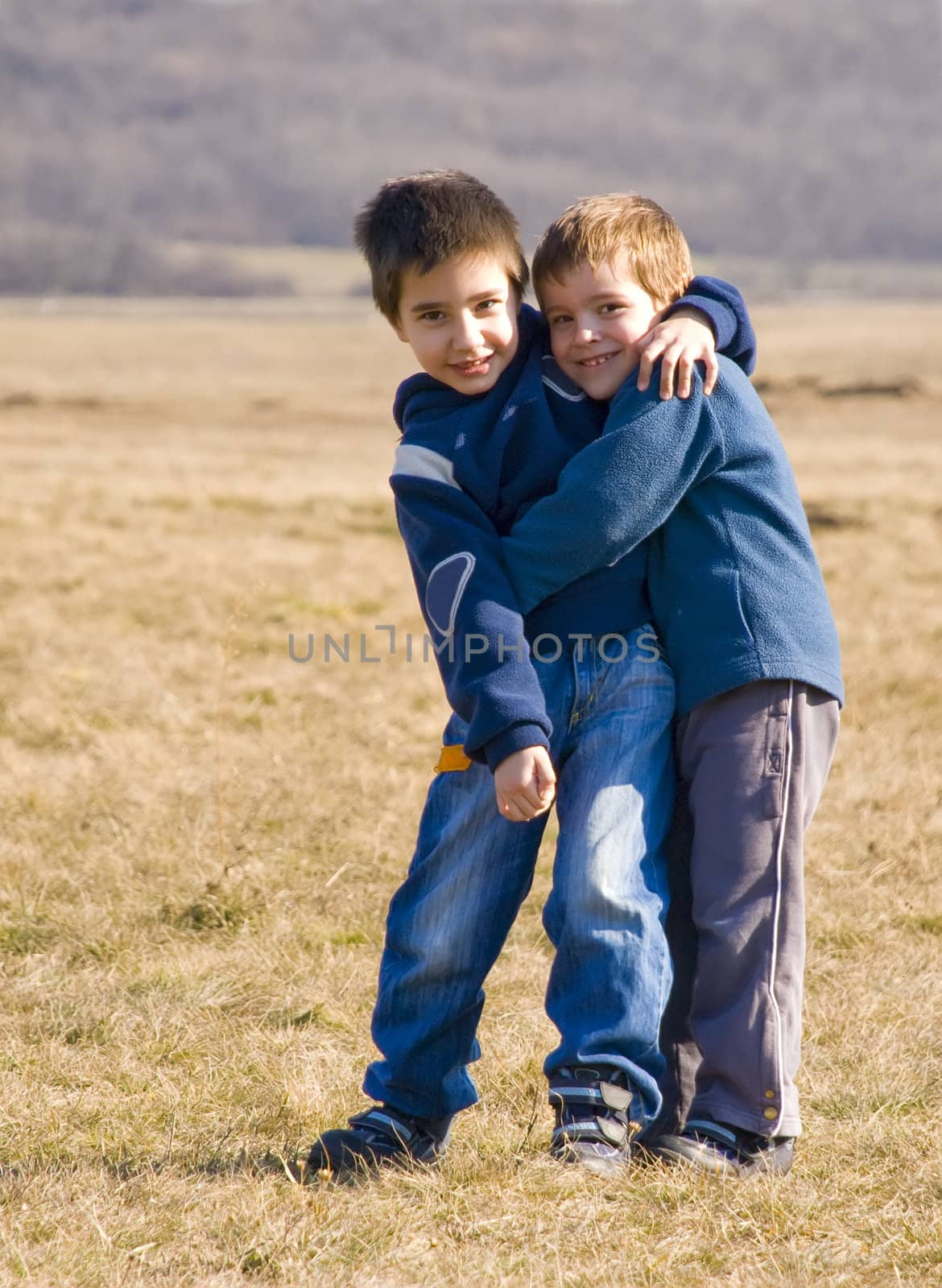 two boys hugging on a sunny day