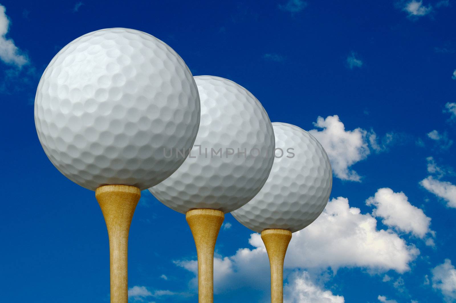 Three Golf Balls & Tees on the left with clouds and sky background.