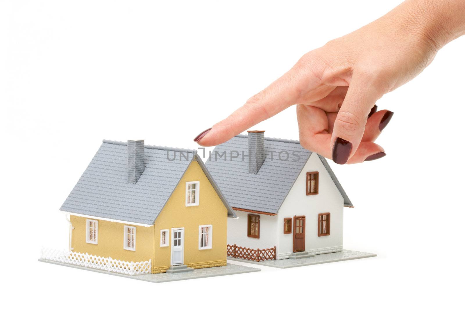 Female hand pointing at a house isolated on a white background.