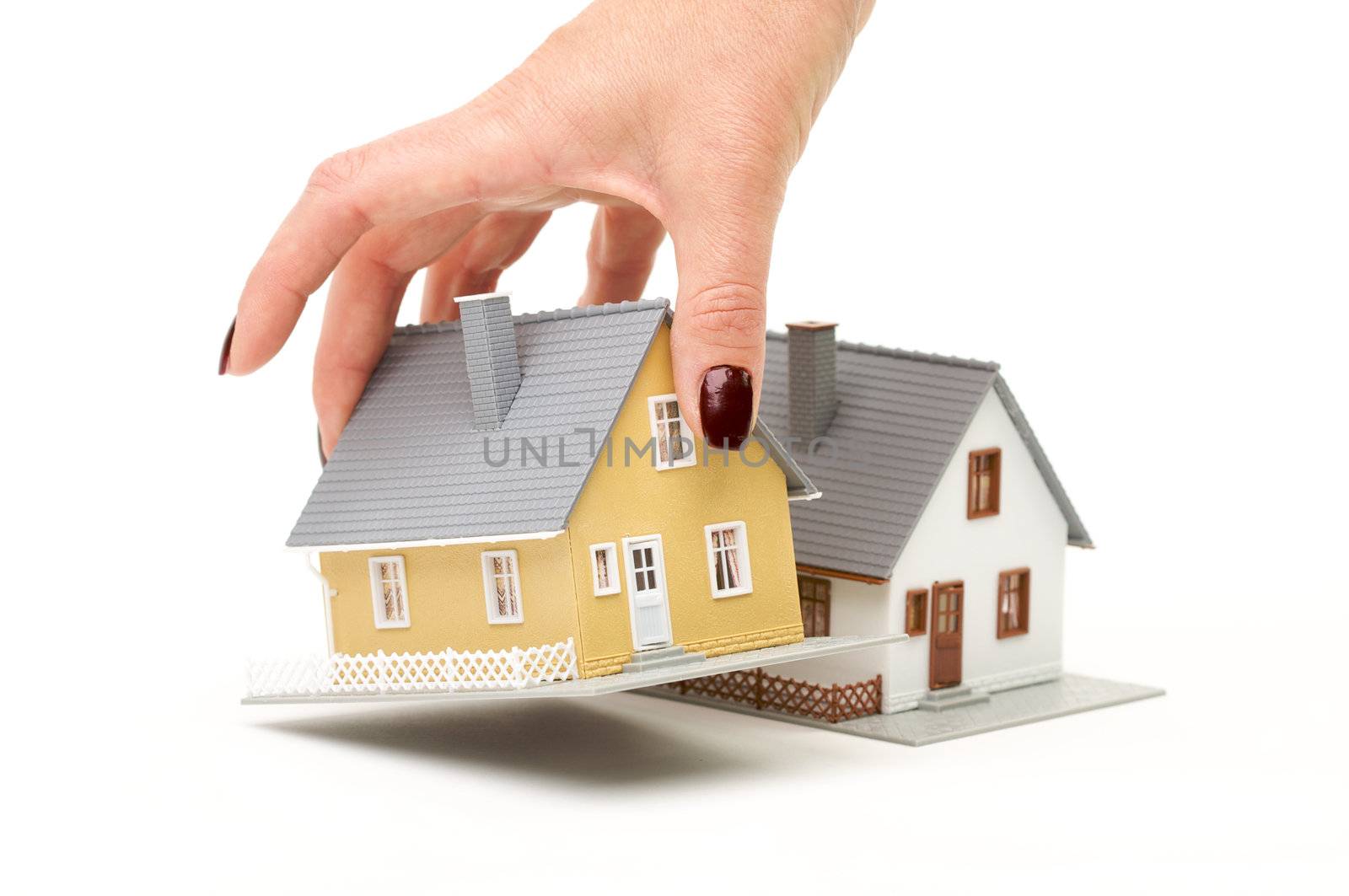 Female hand choosing a house isolated on a white background.