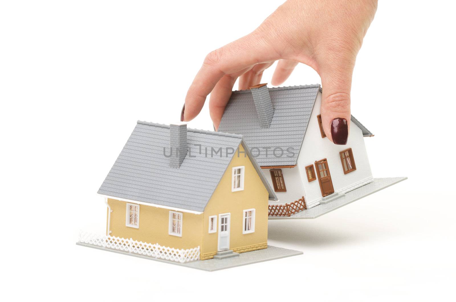 Female hand choosing a house isolated on a white background.