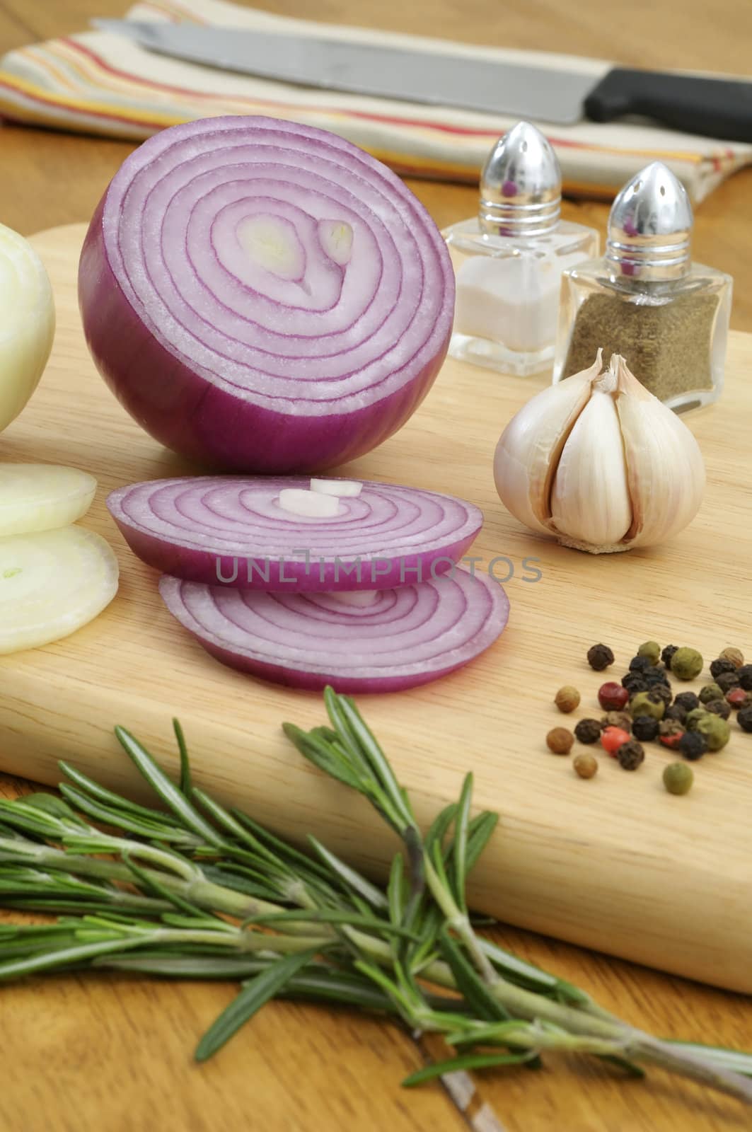 Seasoning ingredients on a chopping board in the kitchen - Focus on Spanish onion and garlic