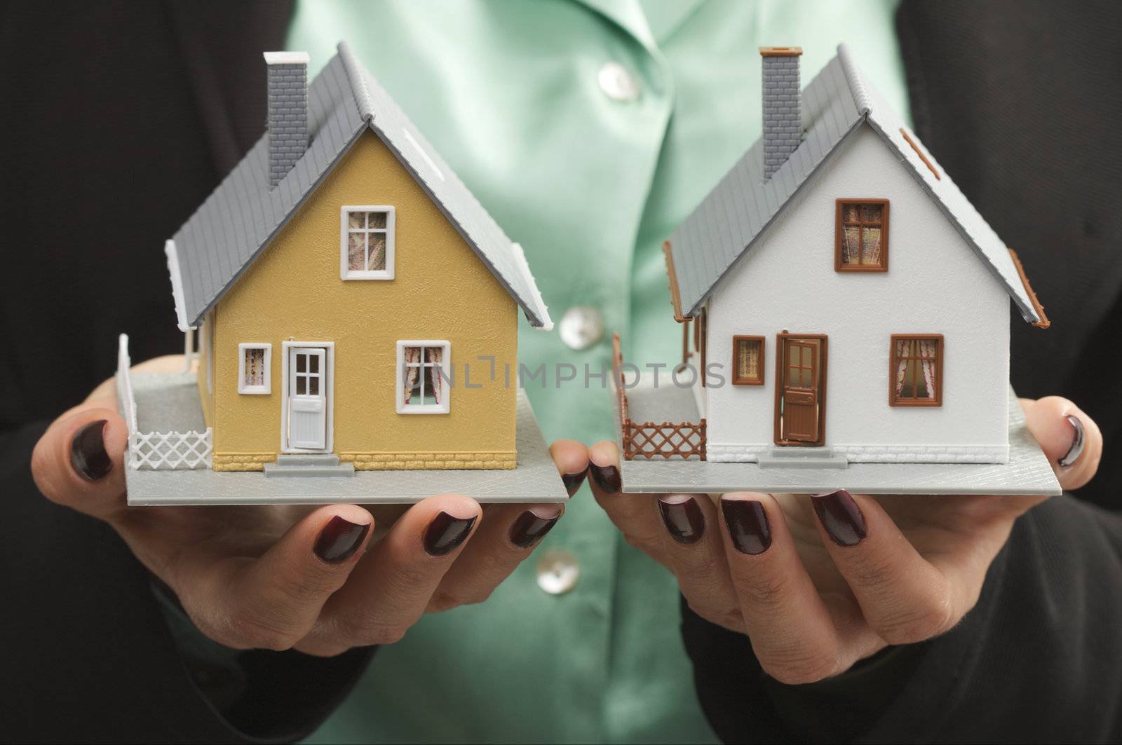 Female hands holding two houses.