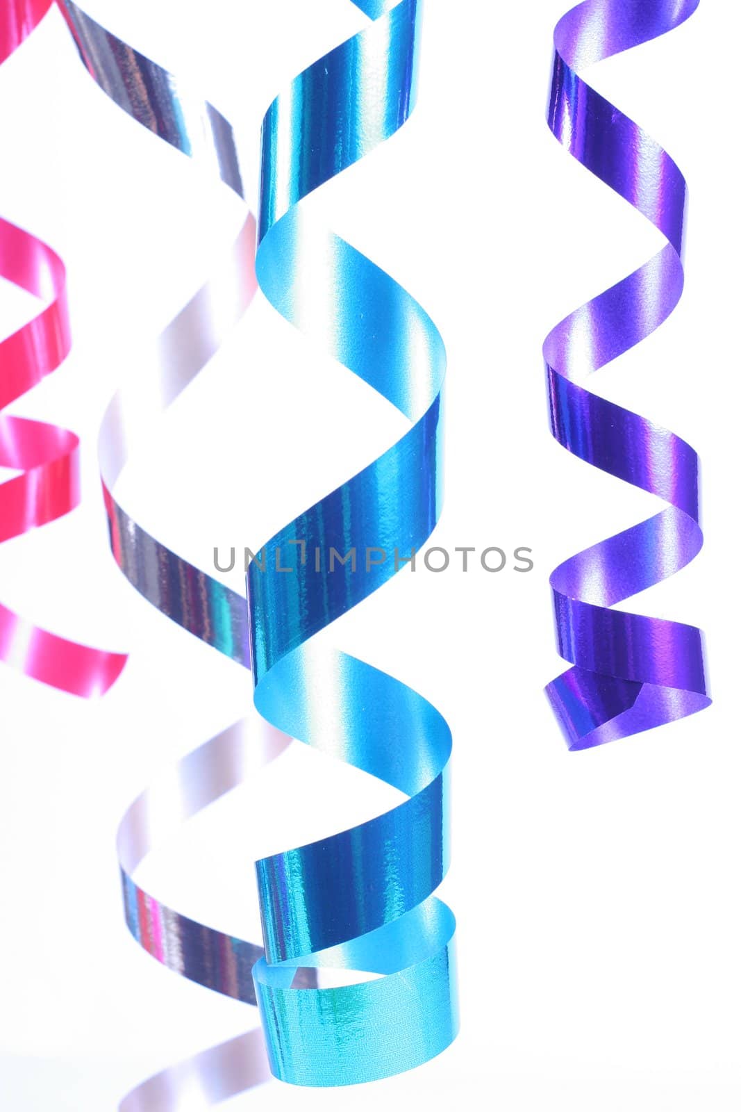 Shiny colorful satin ribbons hanging in curls. Holiday, celebration, party theme.