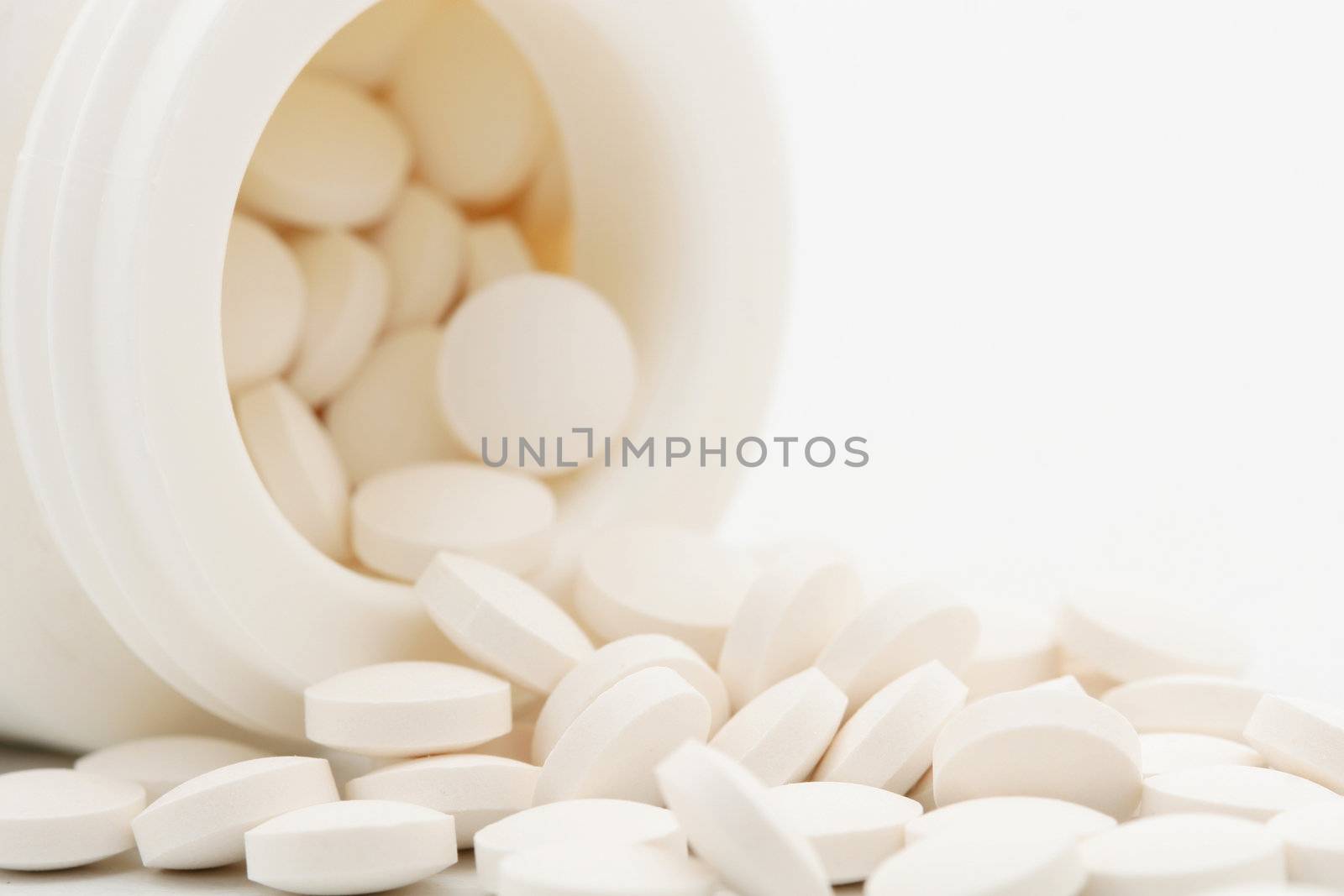 A close up of a box of pills, pills pouring out, shot on white