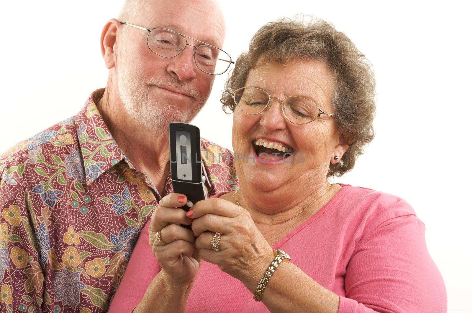 Senior Couple looks at the screen of a cell phone.