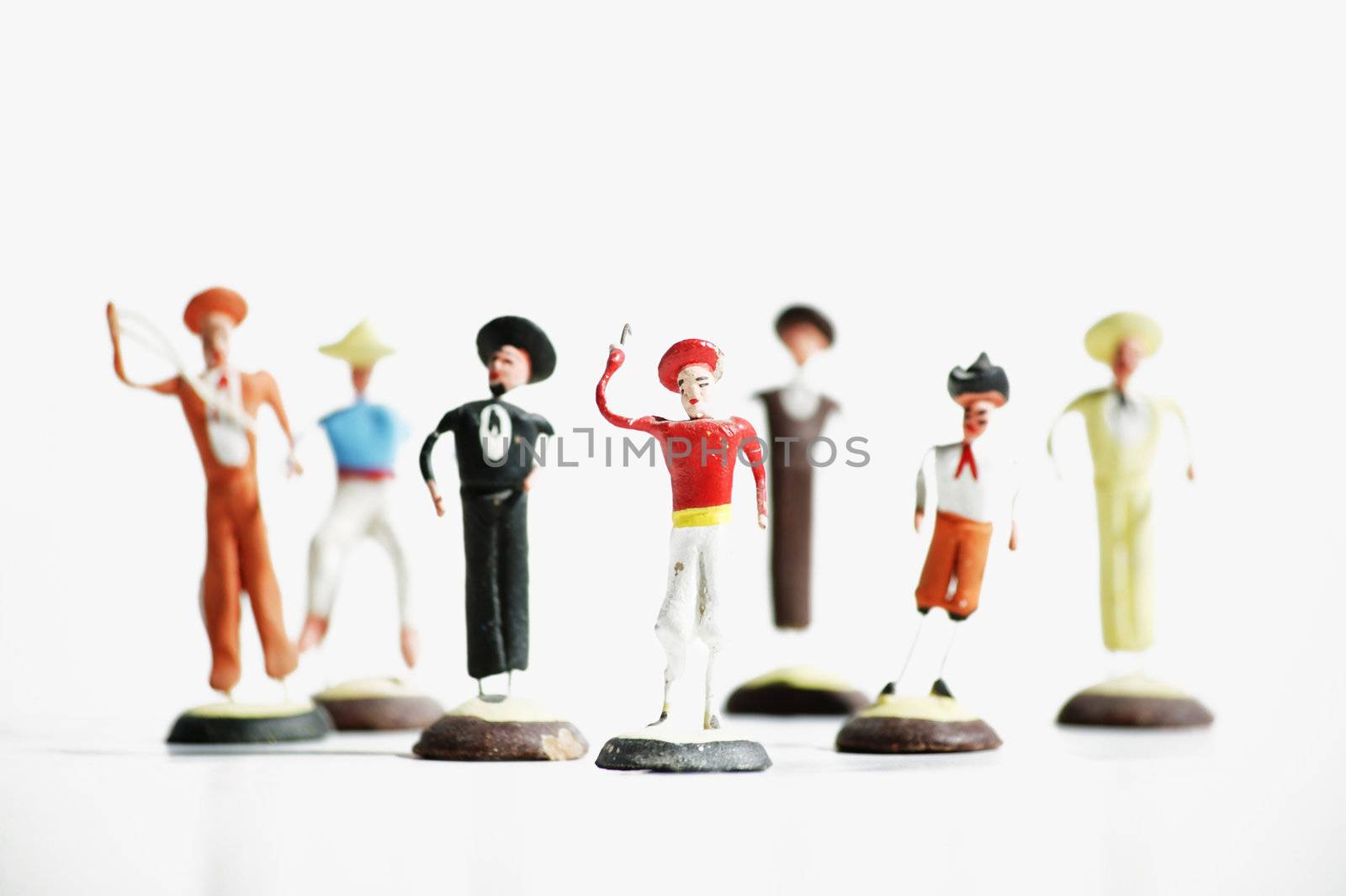 Whimsical mexican clay toy cowboys on a white background.