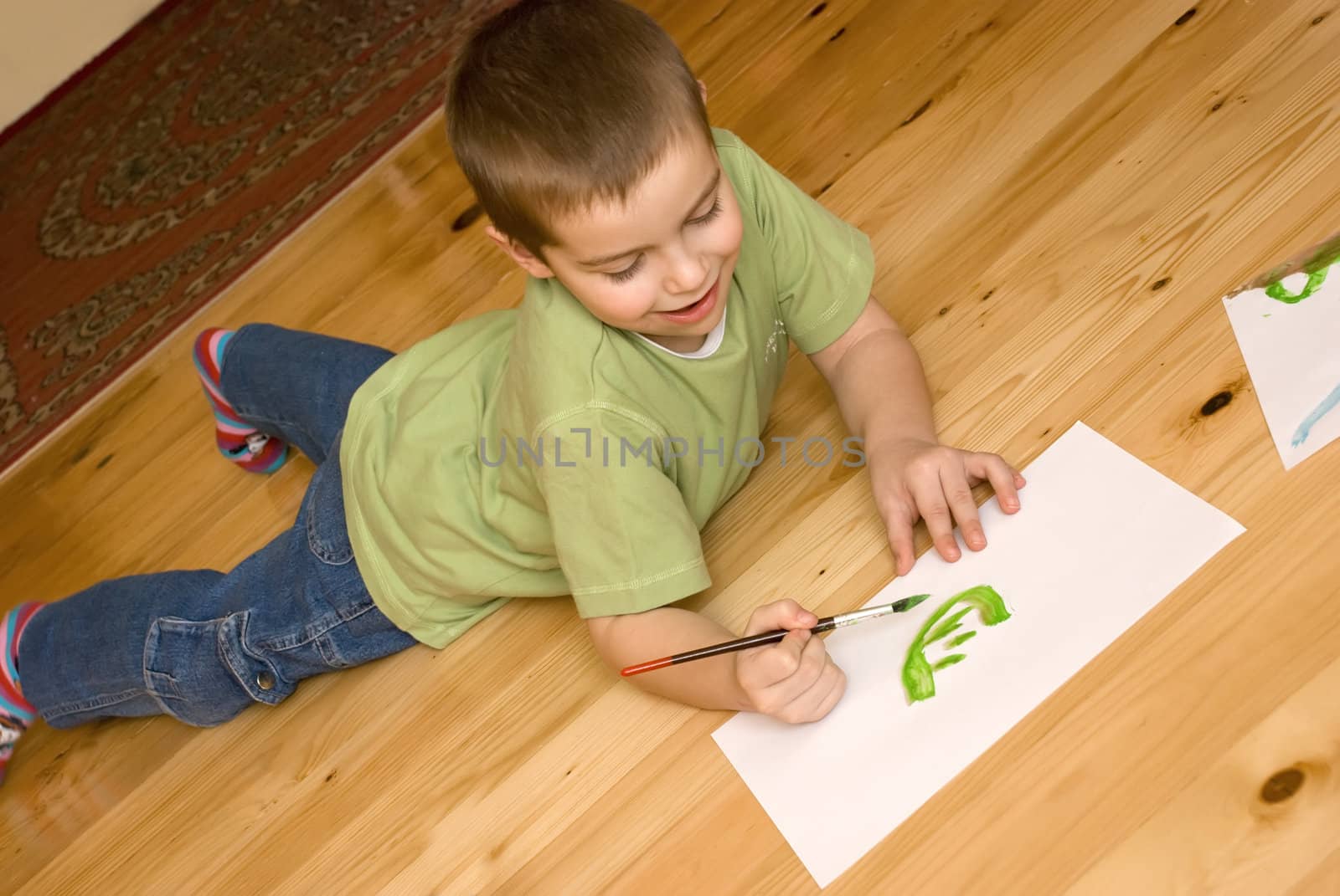 a boy is painting on the floor