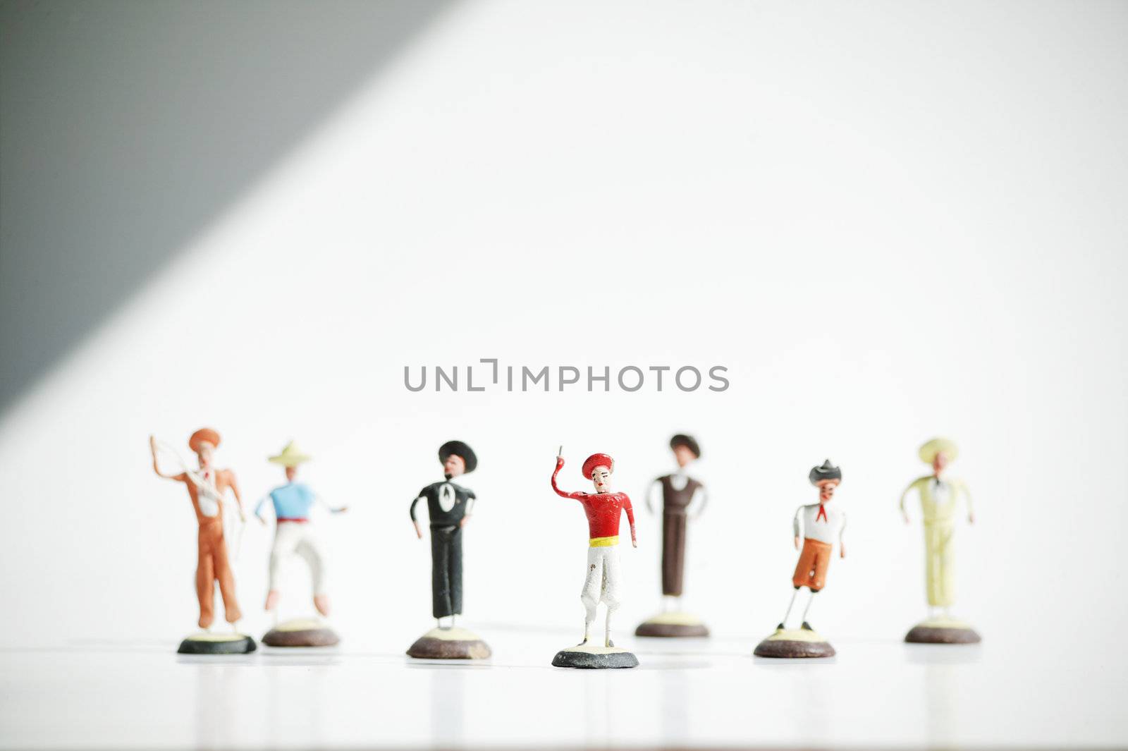 Whimsical mexican clay toy cowboys on a white background.