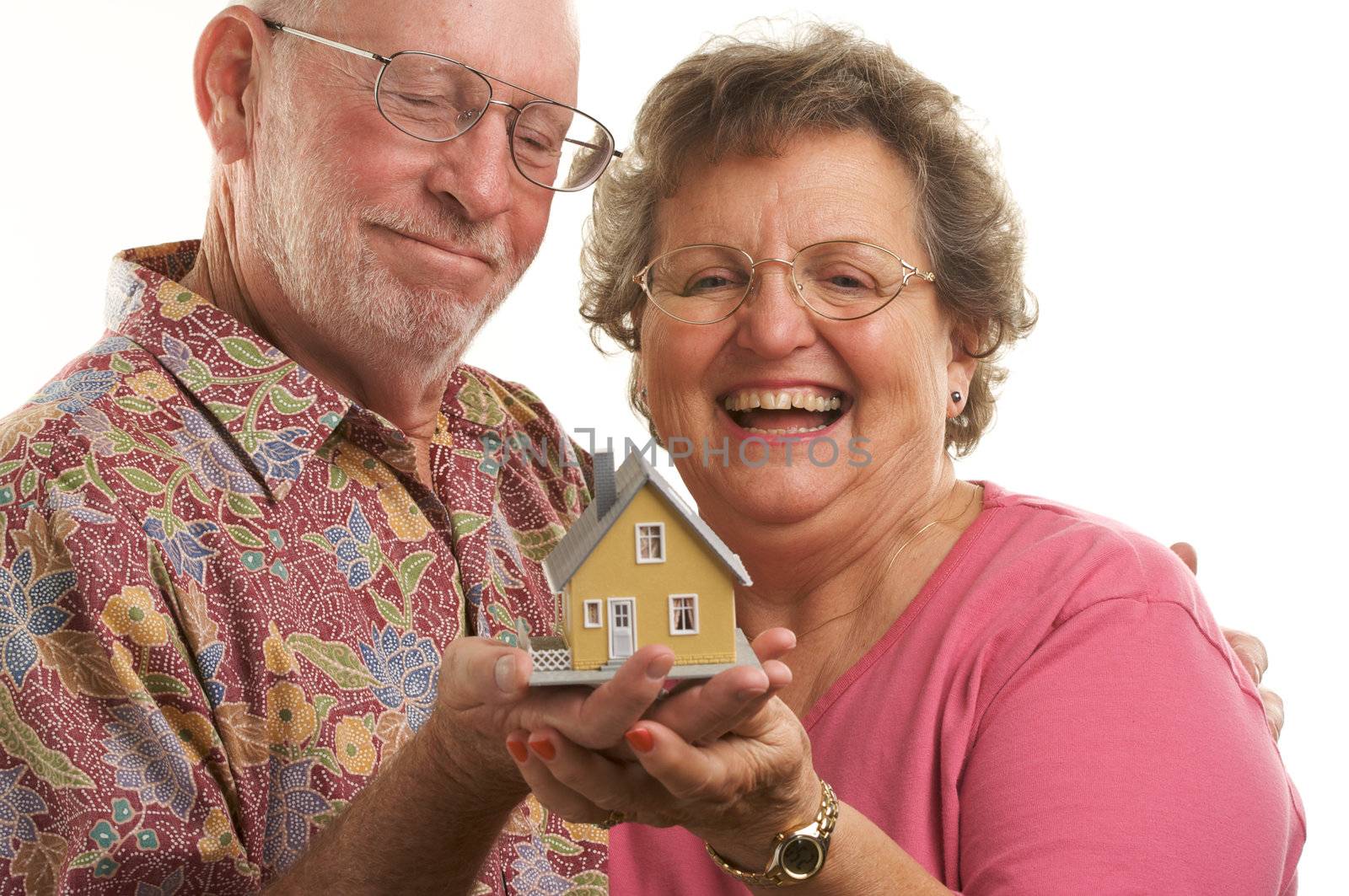Happy Senior Couple holding a model home.