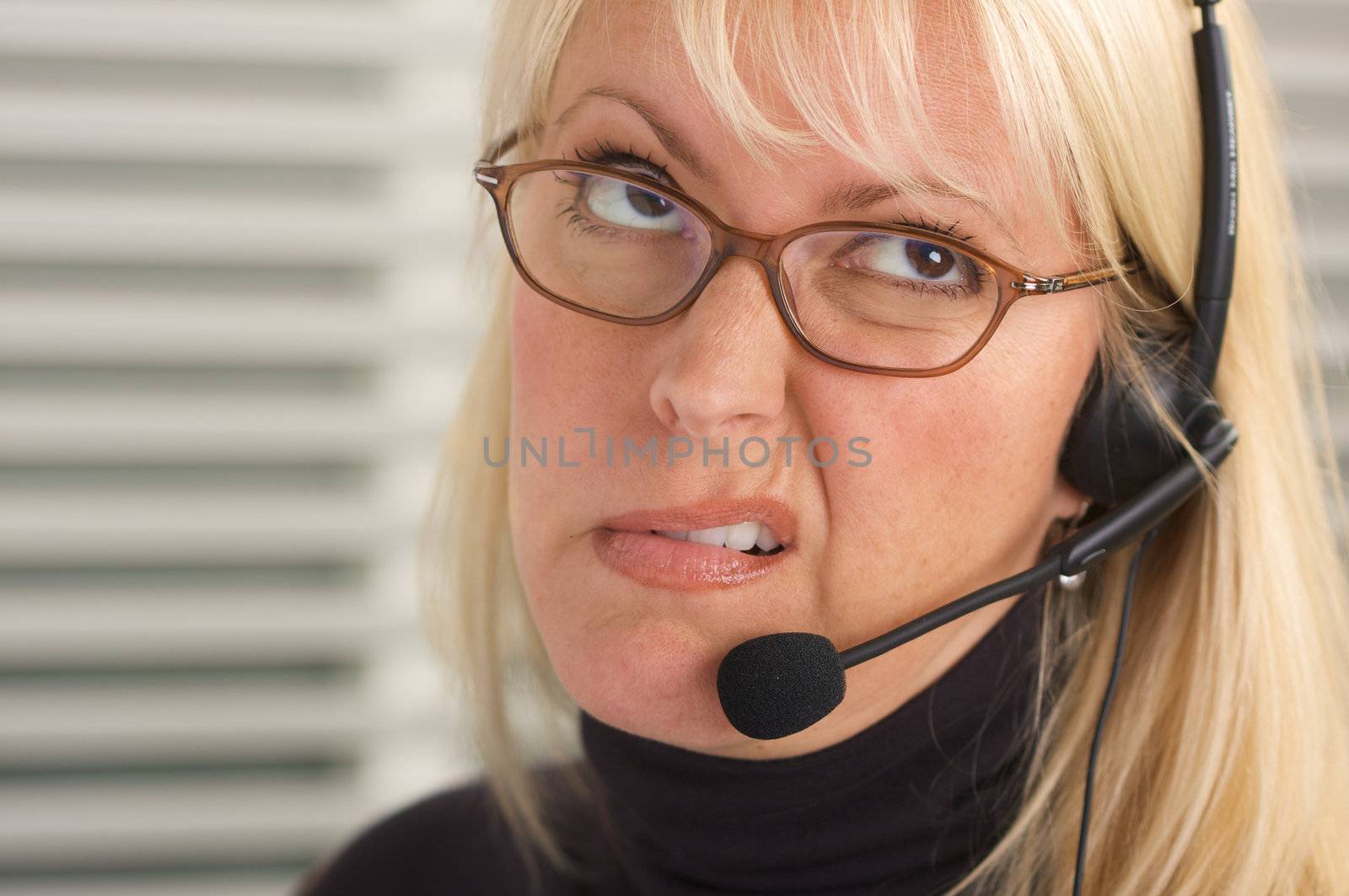 Attractive businesswoman talks on her phone headset.