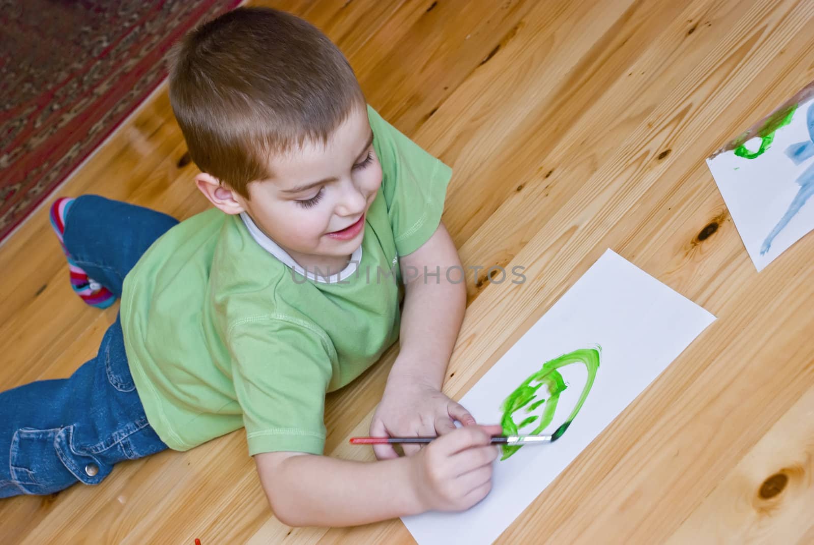 a boy is painting on the floor