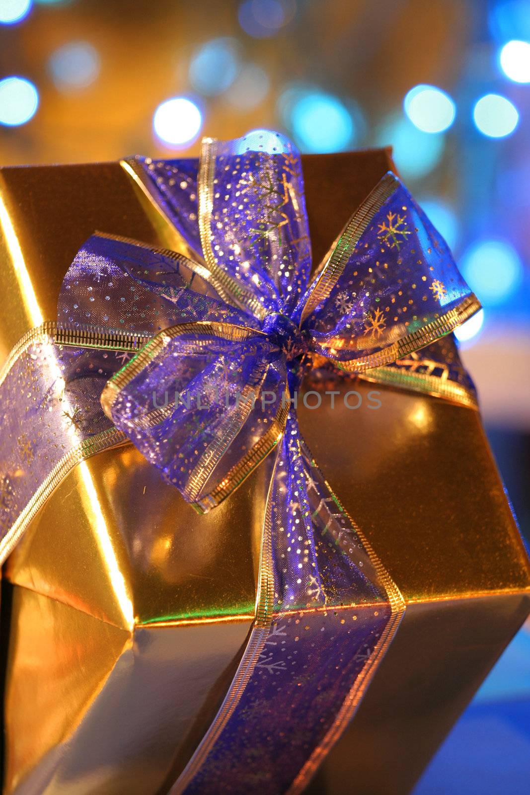 Elegant gold present with blue ribbons against backdrop of blue lights