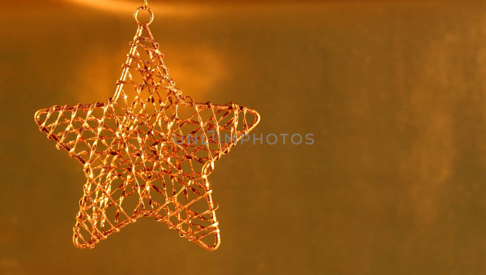 Gold star ornament on gold shiny background.