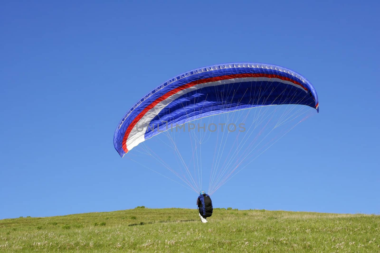 Paraglider take off against a blue sky
