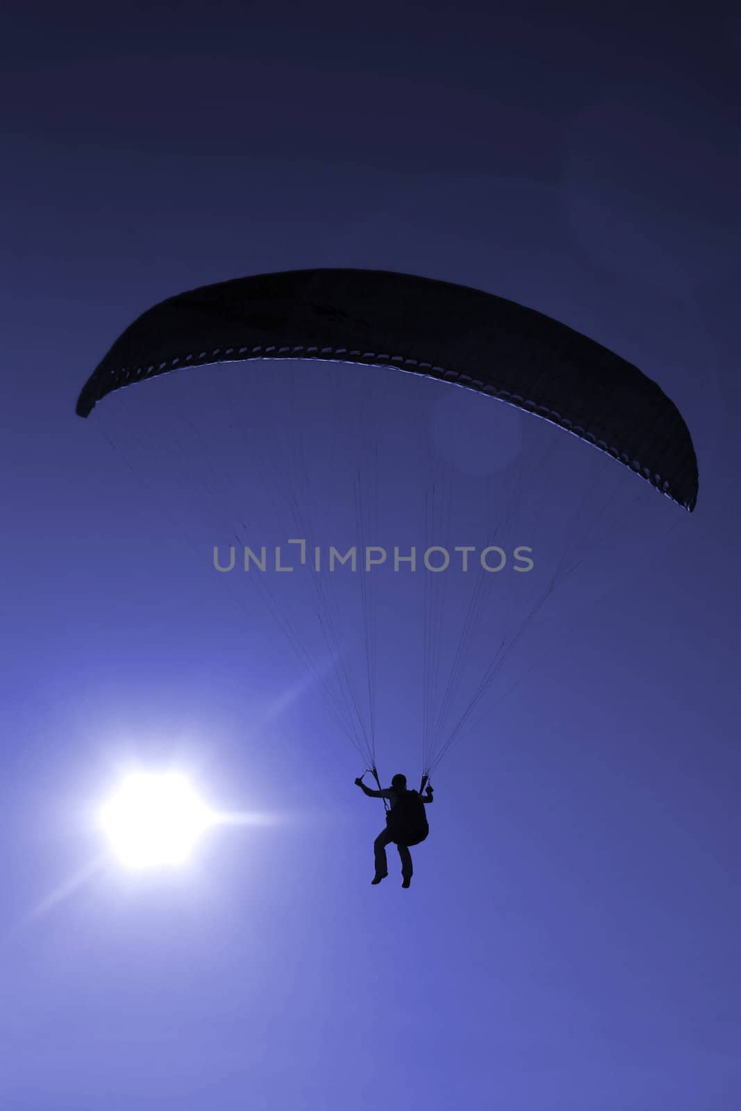 Paraglider flying on sunset