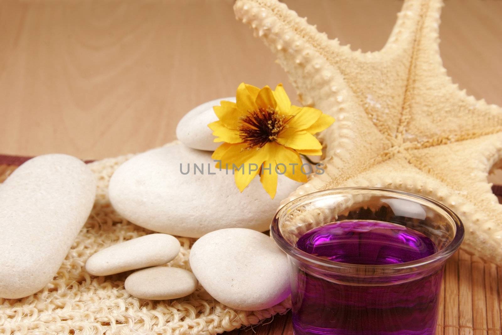 Spa still-life with star fish, stones, flower and aroma therapy bottle