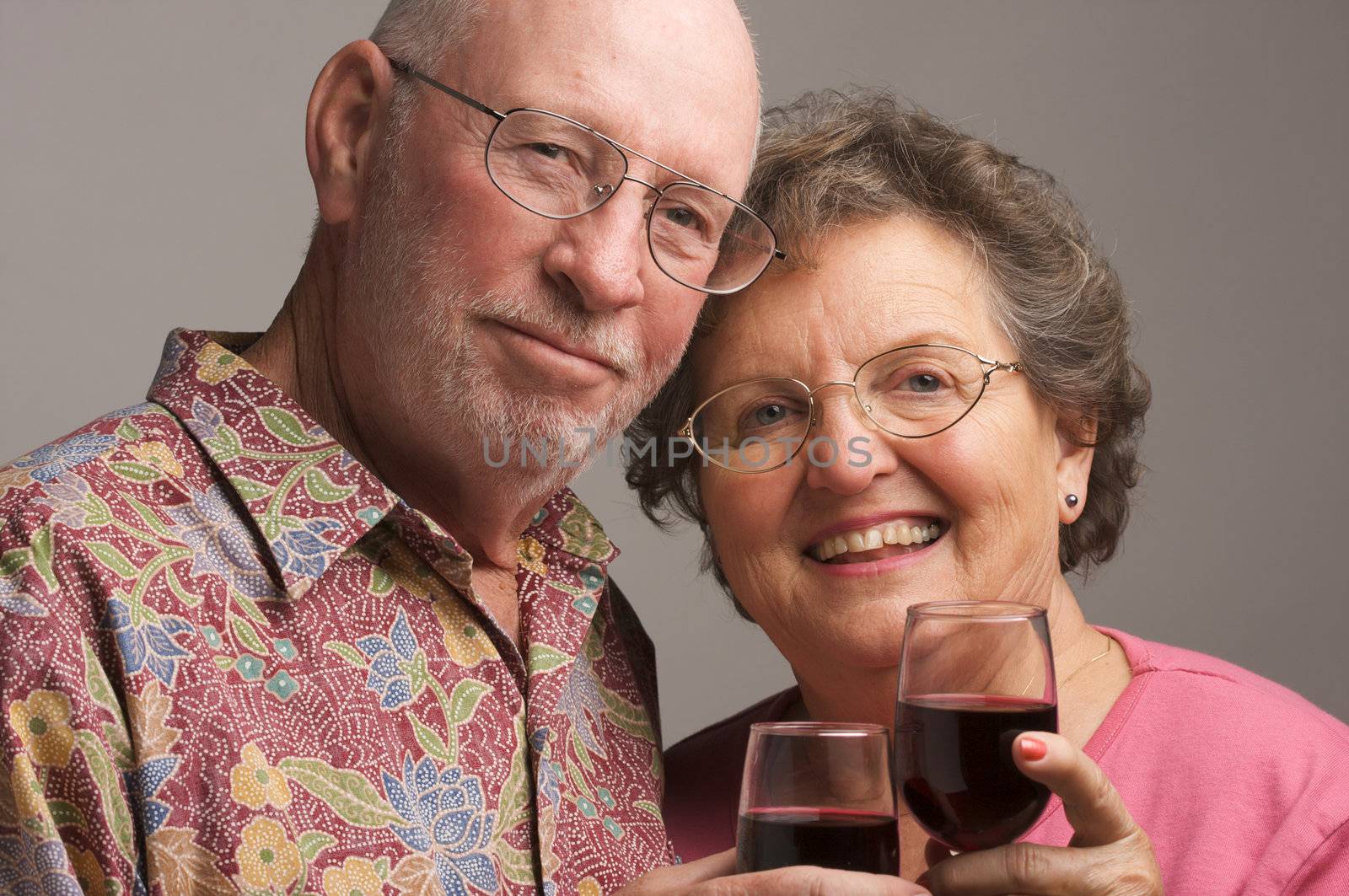 Happy Senior Couple toasting with Winee glasses.