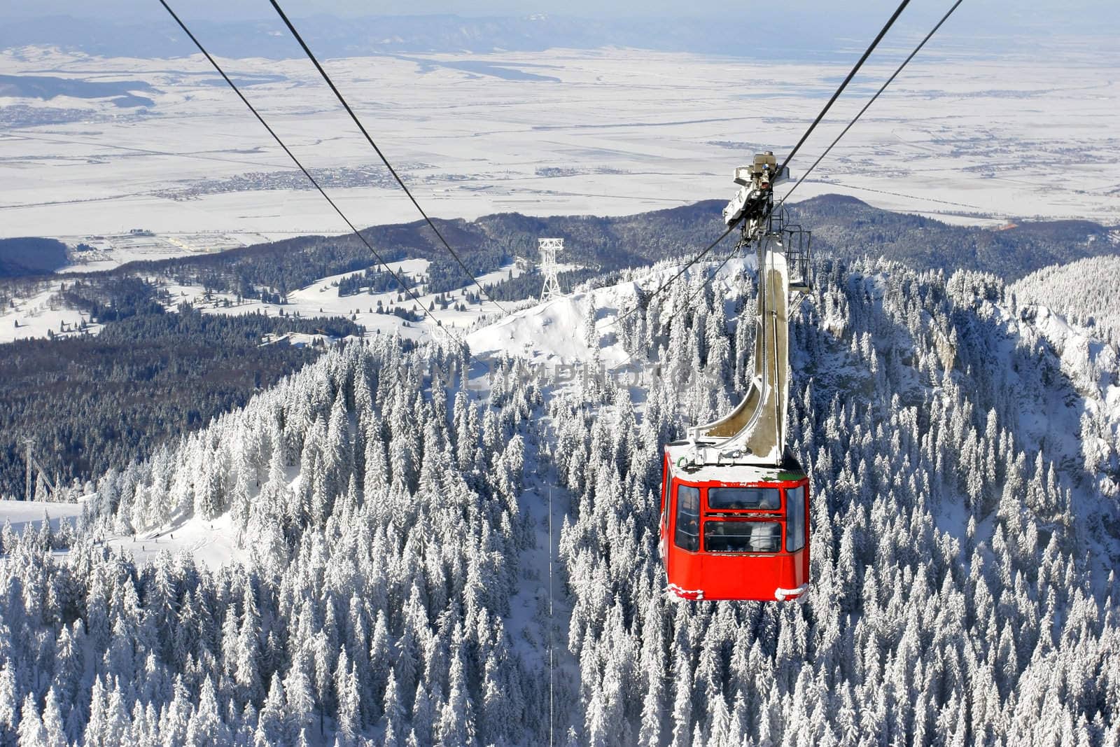 Winter landscape with a red cable car.