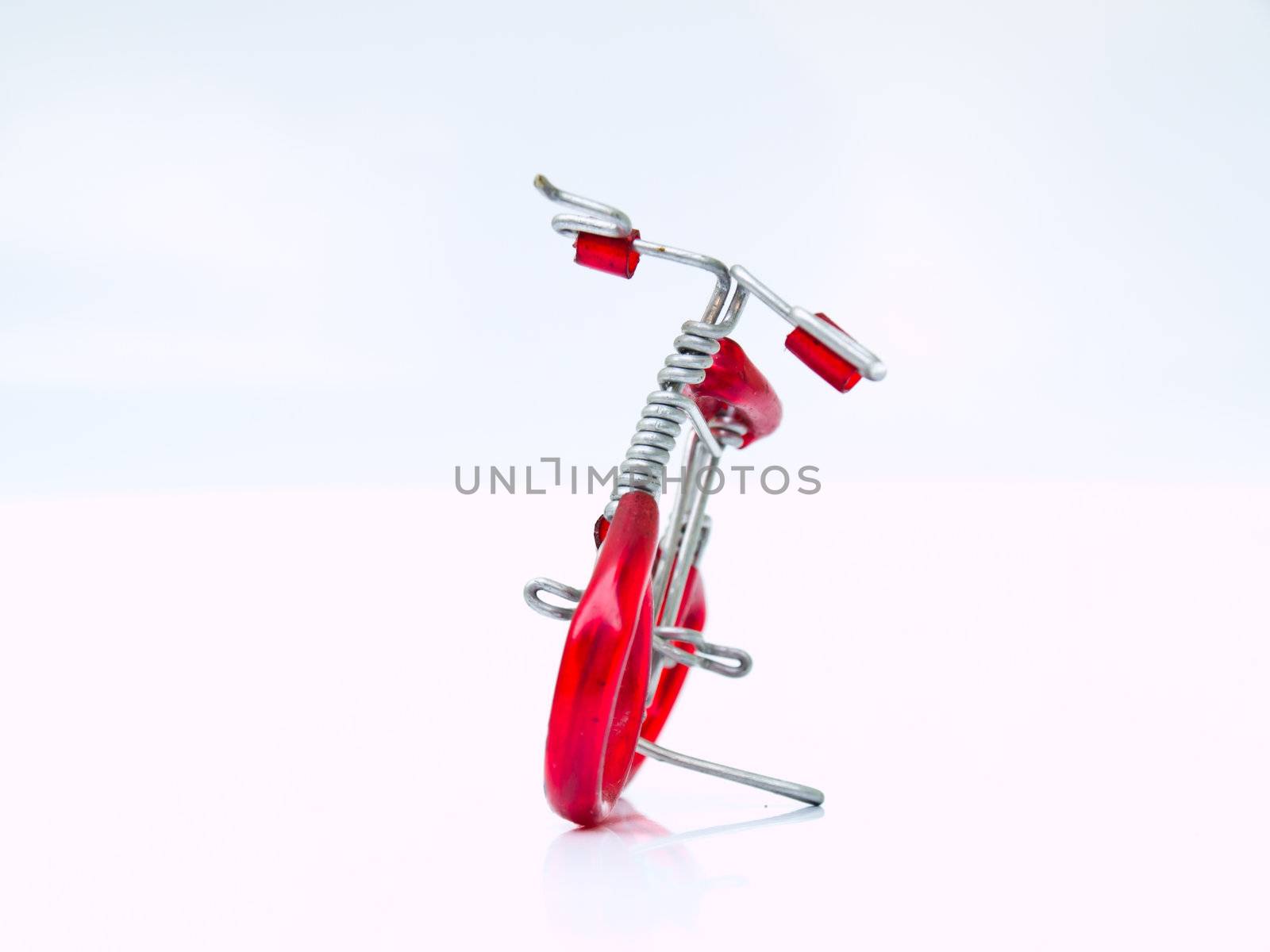 A miniature red bicycle isolated on white background in front vi by gururugu